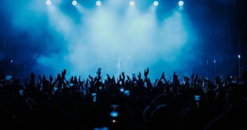 Viele Menschen in einer stark beleuchteten Konzerthalle